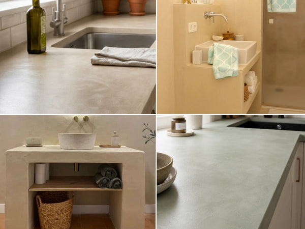 Encimera de baño revestida con microcemento en tono gris claro, con lavabo integrado y grifería negra empotrada en pared, acompañada de accesorios decorativos en madera y fibras naturales.