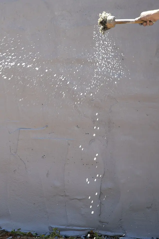 Hombre trabajando en la aplicación de hormigón impreso vertical en un muro exterior