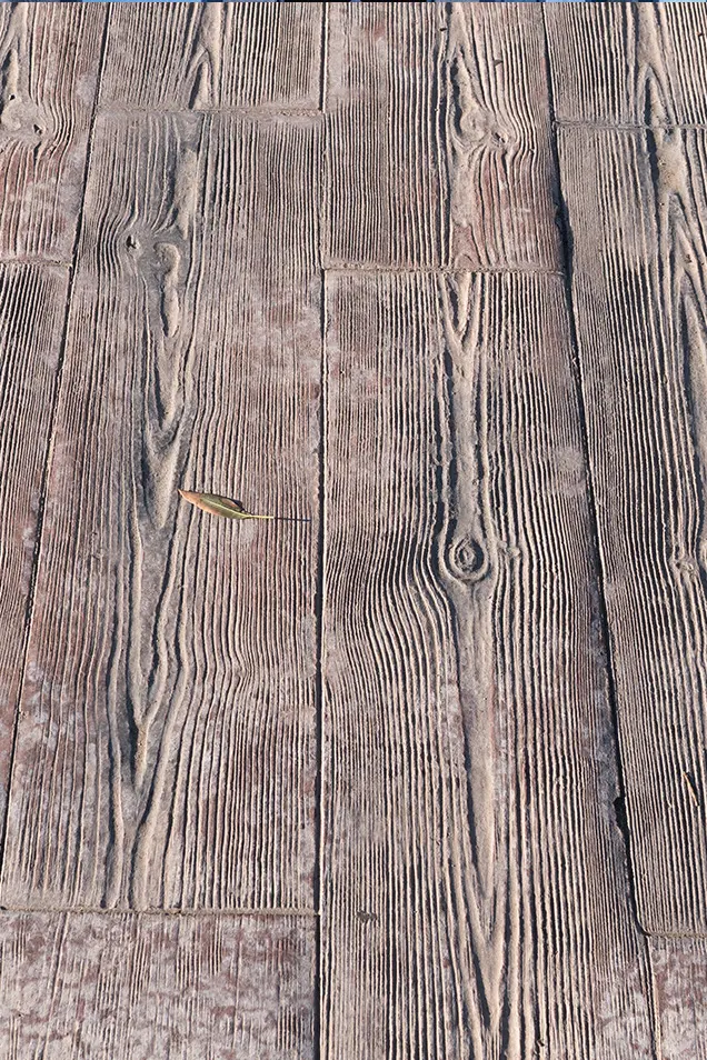 Molde de hormigón impreso imitación madera en un suelo de color marrón.