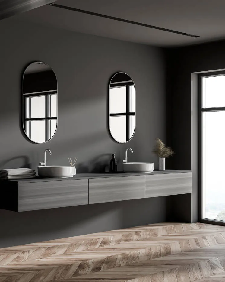 Baño con pared de microcemento y espejos modernos