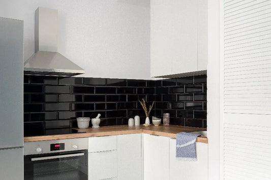 Cocina moderna con azulejos negros pintados y muebles blancos