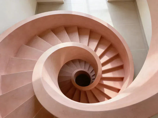 Escalera de microcemento moderna en color coral con diseño en espiral