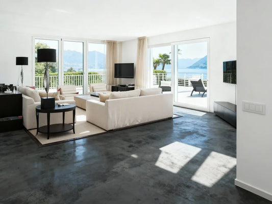 Salón con suelo de microcemento gris oscuro y vistas al mar.