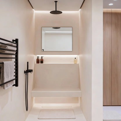 Ducha de obra con microcemento color Blanco Roto con banco integrado, grifería negra y luz indirecta cálida.