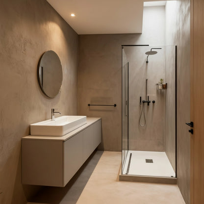 Baño con ducha revestida en microcemento color Café, con paredes en tonos cálidos y mobiliario minimalista.