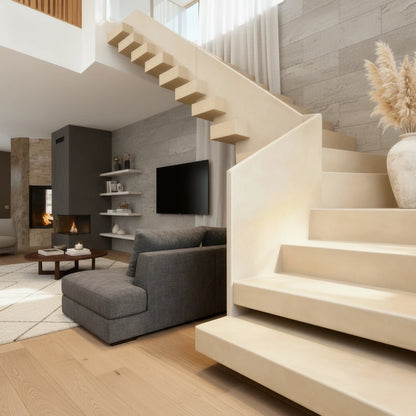  Escalera de obra en microcemento color Porcelain integrada en un salón moderno con luz natural y decoración cálida.