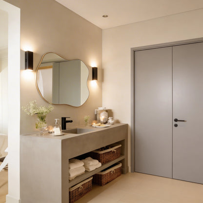 Lavabo de microcemento color Universe integrado en mueble de obra con baldas inferiores y cestas de mimbre, en baño moderno.