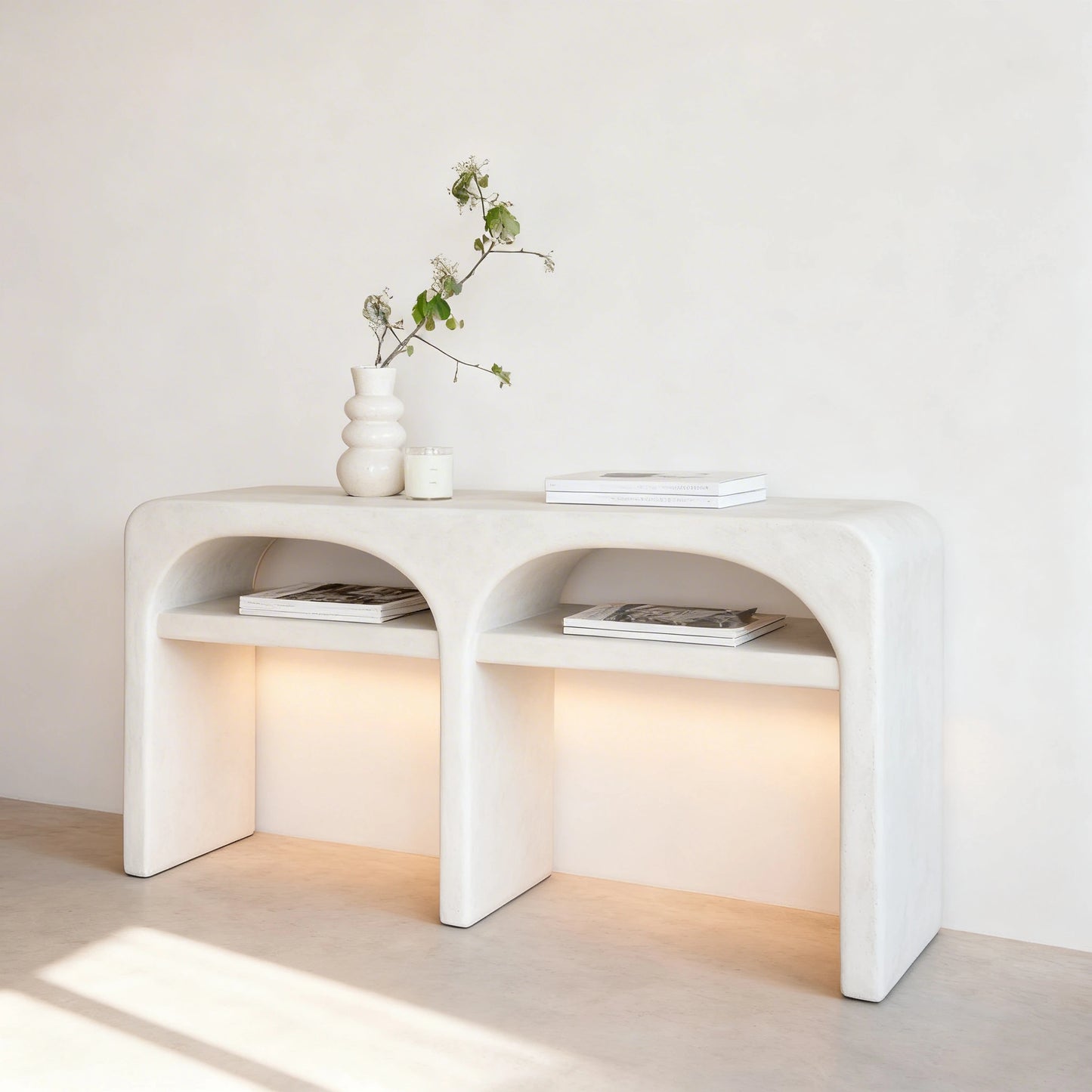 Recibidor de casa con una consola de microcemento color Blanco con formas curvas e iluminado en la parte inferior.