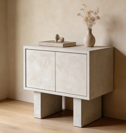 Mueble auxiliar de microcemento en color Papyrus, situado sobre suelo de madera natural en un comedor. 