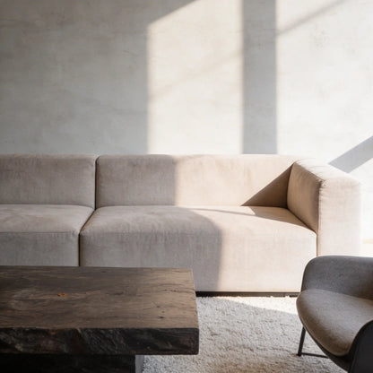 Salón contemporáneo con pared de microcemento gris color Universe, iluminadopor luz natural lateral y mesa de roble macizo.