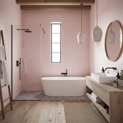 Baño con paredes de microcemento color Blush, bañera exenta y decoración en madera de estilo cálido.