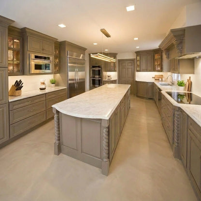 Cocina amplia con pavimento de microcemento beige color Bone, armarios clásicos en tonos neutros, isla central y encimeras claras.