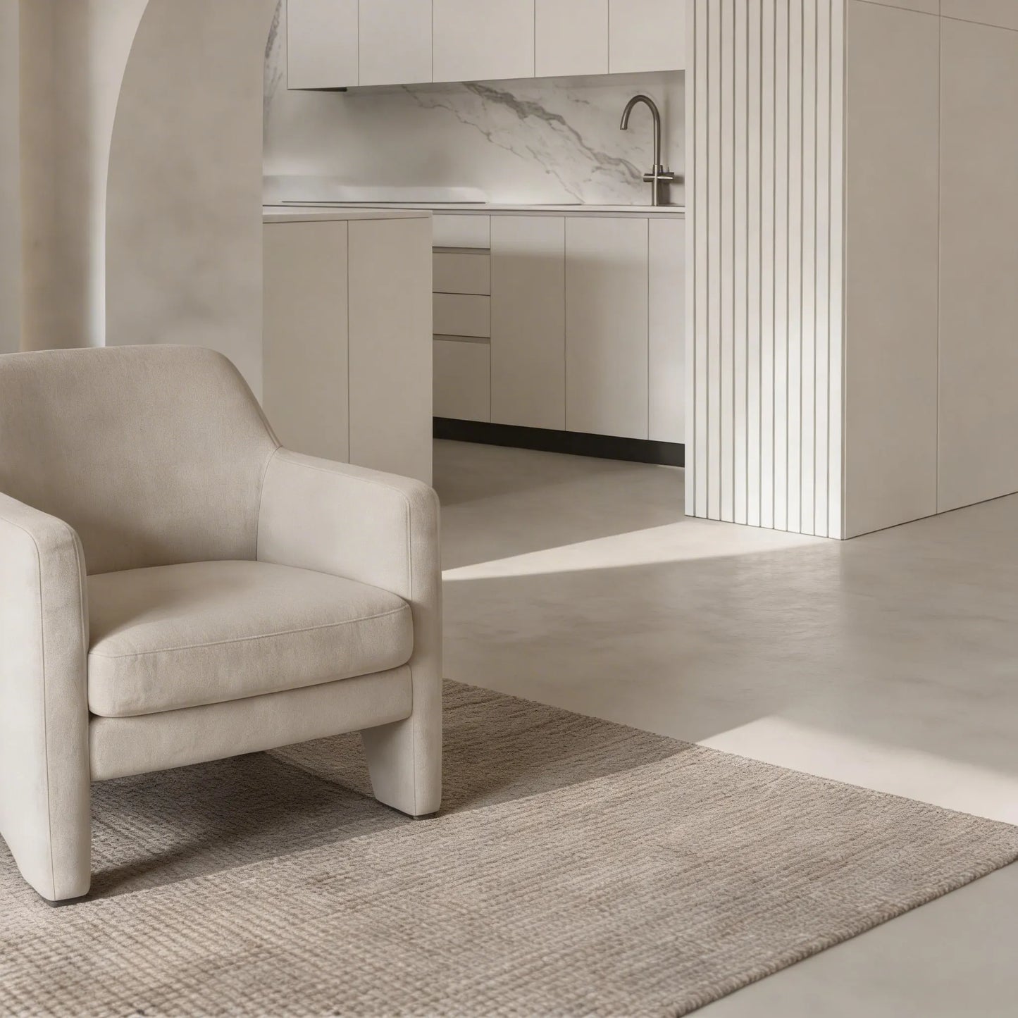 Rincón de estar conectado a una cocina abierta con suelo continuo de microcemento gris color Universe de Smartcret.