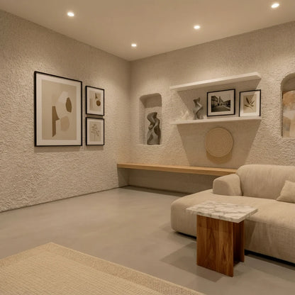 Sala de estar con suelo de microcemento color Spike y paredes de gotelé decoradas con nichos y cuadros modernos.